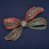 Uitverkoop! Strikbroche met groene, rode en grijze strass-steentjes, antiekgoudkleurig metaal 38×72 mm