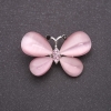 Vlinderbroche met kattenoog roze 37×25 mm zilverachtig metaal